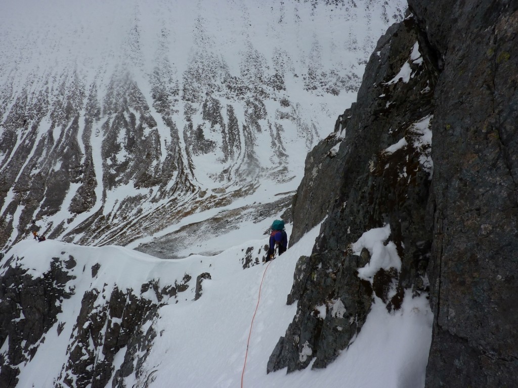 The route then traverses right on an exposed snowy ledge, before turning more steeply up left to regain the crest of the ridge